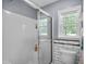 Bright bathroom features a glass-enclosed shower, tiled walls, and a window for natural light at 483 Oakmont Dr., Myrtle Beach, SC 29579