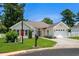 Inviting single-story home with a well-maintained lawn and a white garage door, complemented by red shutters at 483 Oakmont Dr., Myrtle Beach, SC 29579