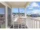 Balcony with white wood furniture overlooking street and building at 5000 N Ocean Blvd. # E-2, North Myrtle Beach, SC 29582