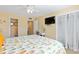 Bright bedroom view with TV, adjacent bathroom, and closet with white curtains at 5000 N Ocean Blvd. # E-2, North Myrtle Beach, SC 29582