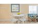 Bright breakfast nook with white table set, cozy chairs and beach-themed decor at 5000 N Ocean Blvd. # E-2, North Myrtle Beach, SC 29582