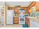 Cozy kitchen with wood cabinetry, white appliances, and colorful backsplash at 5000 N Ocean Blvd. # E-2, North Myrtle Beach, SC 29582