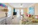 Inviting living room featuring a comfortable green sectional and a sliding door to a balcony at 5000 N Ocean Blvd. # E-2, North Myrtle Beach, SC 29582