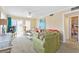 Bright living room with a comfortable green couch, balcony access, and a peek into the bathroom at 5000 N Ocean Blvd. # E-2, North Myrtle Beach, SC 29582