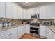 Modern kitchen features granite countertops, a tile backsplash, and stainless steel appliances for a chef-inspired experience at 505 41St Ave. S, North Myrtle Beach, SC 29582