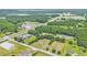 Aerial view of property showing mature trees, a home, a field, and nearby commercial area at 580 Circle M Rd., Longs, SC 29568
