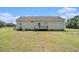 View of the back of home and lawn, including a small deck at 580 Circle M Rd., Longs, SC 29568