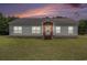 Charming single-story home with vinyl siding, a brick foundation, and well-manicured lawn at sunset at 580 Circle M Rd., Longs, SC 29568
