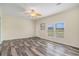 Bright living room featuring wood-look floors, a decorative fan, and natural light from the windows at 580 Circle M Rd., Longs, SC 29568