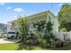 Charming home exterior features lush greenery, a white porch, and mature trees, creating a serene setting at 5867 Rosewood Dr., Myrtle Beach, SC 29588