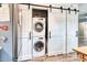 Convenient laundry area featuring a stacked washer and dryer and sliding barn doors for storage at 5867 Rosewood Dr., Myrtle Beach, SC 29588