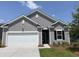 Charming single-story home with gray siding, white trim, and an attached two-car garage with manicured front lawn at 606 Muster Field Ct., Conway, SC 29526