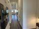 Long hallway featuring wood-look flooring, neutral paint, and ample lighting leading to living spaces at 606 Muster Field Ct., Conway, SC 29526