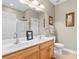 Clean bathroom featuring double sinks, a large mirror, a shower with glass doors, and light wood cabinets at 6095 Catalina Dr. # 616, North Myrtle Beach, SC 29582