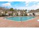 Community pool featuring a brick patio and a view of surrounding townhomes and palm trees at 6095 Catalina Dr. # 616, North Myrtle Beach, SC 29582