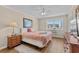 A bedroom with wood floors, a large window, a ceiling fan, and a wooden dresser at 6301 N Ocean Blvd. # 2B, North Myrtle Beach, SC 29582