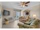 Nicely decorated living area has a flat screen TV, ceiling fan, and sliding glass door to a balcony at 6301 N Ocean Blvd. # 2B, North Myrtle Beach, SC 29582