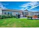 Green backyard featuring a patio with seating, a grill, flowering bushes, and a landscaped lawn at 6430 Cascata Dr., Myrtle Beach, SC 29572