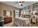 Comfortable bedroom featuring a ceiling fan, a paisley bedspread, and a plaid accent wall at 6430 Cascata Dr., Myrtle Beach, SC 29572