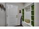 Mud room featuring a white door, a built-in storage bench with green cubbies, and hooks at 6430 Cascata Dr., Myrtle Beach, SC 29572