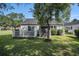 Backyard view featuring a wooden deck, storage shed, lush green lawn, and shade tree at 6570 Pebble Beach Crescent, Myrtle Beach, SC 29588