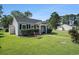 Quaint, single-story home with well-kept lawn, complemented by a cozy red bench and manicured hedges at 6570 Pebble Beach Crescent, Myrtle Beach, SC 29588