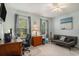 Bright office area with a ceiling fan, couch, work desk, and natural light from two windows at 6570 Pebble Beach Crescent, Myrtle Beach, SC 29588