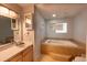 Bathroom featuring a large soaking tub with decorative tile surround and vanity at 6936 Woodhaven Dr., Myrtle Beach, SC 29588