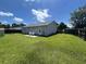 Grassy fenced backyard with small patio, exterior door and light gray siding at 706 Jamie Ln., Conway, SC 29526