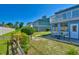 Landscaped backyard featuring a patio area with seating, mature trees, and green space at 832 Villa Dr. # 832, North Myrtle Beach, SC 29582