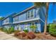 Exterior of condo with palm tree, flowers, and landscaping on a sunny day at 832 Villa Dr. # 832, North Myrtle Beach, SC 29582