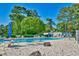 Community pool with lounge chairs surrounded by lush greenery and a blue sky at 832 Villa Dr. # 832, North Myrtle Beach, SC 29582