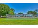 Tennis court with green turf surrounded by a fence and lush green trees at 832 Villa Dr. # 832, North Myrtle Beach, SC 29582