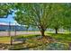 Tennis courts with mature shade trees and benches offering a recreational space at 832 Villa Dr. # 832, North Myrtle Beach, SC 29582