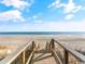 Beautiful beach access with wooden stairs leading down to the sandy shoreline and ocean views at 8488 Idlewood Dr., Myrtle Beach, SC 29588