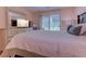 Bright bedroom features a queen bed, dresser with TV, and a sliding glass door to the outside at 850 Fairway Dr. # 904Ee, Longs, SC 29568