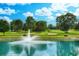 Scenic pond with a fountain and lush greenery under a blue sky with puffy clouds at 850 Fairway Dr. # 904Ee, Longs, SC 29568