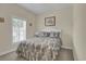 Cozy bedroom featuring a queen bed with a floral comforter and a window with blinds at 8855 Radcliff Dr. Nw # 50B, Calabash, NC 28467