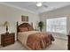 Cozy bedroom with a decorative headboard, ceiling fan, and a window providing natural light at 8855 Radcliff Dr. Nw # 50B, Calabash, NC 28467