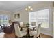 Bright dining area with wood floors, a modern chandelier, and views into the cozy living space at 8855 Radcliff Dr. Nw # 50B, Calabash, NC 28467
