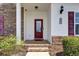 Inviting entryway with a red front door, brick steps, and decorative plants adding curb appeal at 8855 Radcliff Dr. Nw # 50B, Calabash, NC 28467