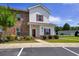 Charming two-story townhome with brick and siding, complemented by colorful landscaping and a well-maintained lawn at 8855 Radcliff Dr. Nw # 50B, Calabash, NC 28467