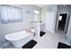 Elegant bathroom with a freestanding tub, vanity with marble countertop, and neutral tile flooring at 1455 Whooping Crane Dr., Conway, SC 29526