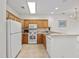 Well-lit kitchen with white appliances, wood cabinets, and a breakfast bar at 155 Chenoa Dr. # D, Murrells Inlet, SC 29576