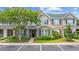 Charming townhome with brick accents, green shutters, a black front door and lush landscaping at 155 Chenoa Dr. # E, Murrells Inlet, SC 29576