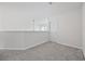Upstairs hallway with neutral walls and carpet that leads to a door with a window at 155 Chenoa Dr. # E, Murrells Inlet, SC 29576