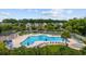 Community pool featuring lounge chairs, umbrellas, and jacuzzi nestled amongst green trees and townhomes at 155 Chenoa Dr. # E, Murrells Inlet, SC 29576