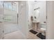 Half bath with a pedestal sink, decorative mirror, and tile floors, with a view into the living area at 155 Chenoa Dr. # E, Murrells Inlet, SC 29576