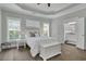 Serene main bedroom with tray ceiling, plantation shutters, and ensuite bathroom access at 1584 Sand Harbor Cir. # 1584, Ocean Isle Beach, NC 28469