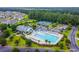 Aerial view of a community clubhouse, pool, and tennis courts nestled among mature trees at 2131 Cass Lake Dr. # 662, Carolina Shores, NC 28467